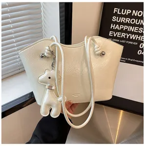 Detail der cremefarbenen Falten-Tote-Bag mit Silberperlen und Tieranhänger im Urban-Stil