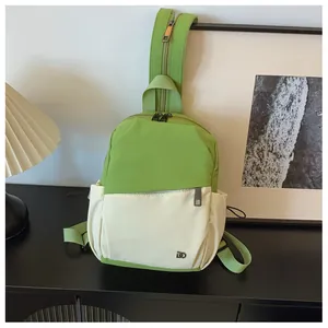 Detalle del bolso bandolera de nailon verde con logo metálico en un fondo minimalista