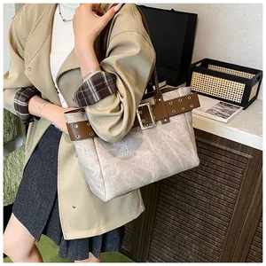 Große beige Tragetasche mit Vintage-Lederriemen und Metallschnallen im Detail