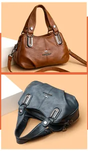 Detailed macro view of litchi grain leather texture and metallic logo on women's handbag
