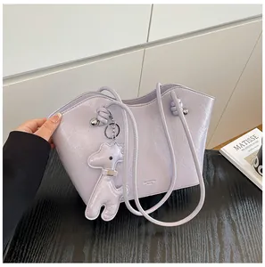 Detailaufnahme der hellvioletten Tragetasche mit glänzendem Finish und Hundeanhänger