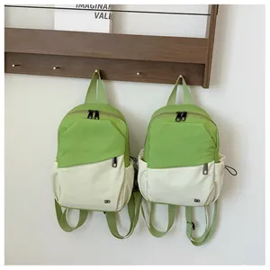 Detalle de mini mochila de nailon bicolor con bolsillo verde y logotipo LD impreso