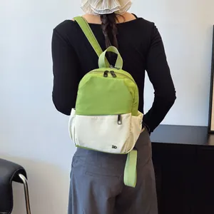 Mini mochila multifuncional en verde y beige con correas ajustables y logotipo metálico