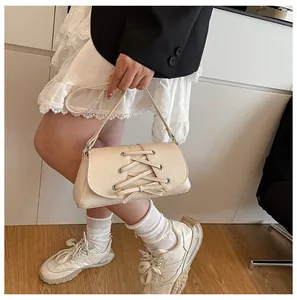 Chic cream crossbody bag with bow-knot lace detail shown on a model's outfit