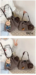 Detail of brown canvas bucket bag set with woven leather strap and plush rabbit charm