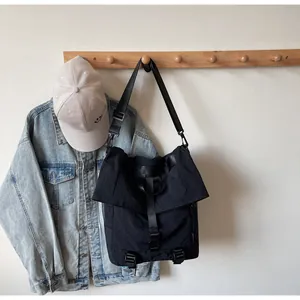 Λεπτομέρεια μαύρης τσάντας ταχυδρόμου από νάιλον με ρυθμιζόμενο κλείσιμο με πόρπη