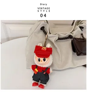 Close-up of Labubu plush doll keychain with red cap and overalls on a canvas tote bag