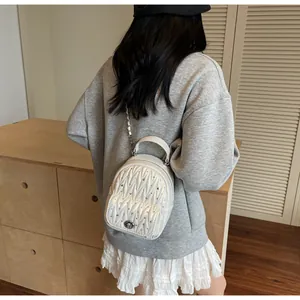 Detail of white quilted leather mini bag featuring crystal rhinestones and chain strap