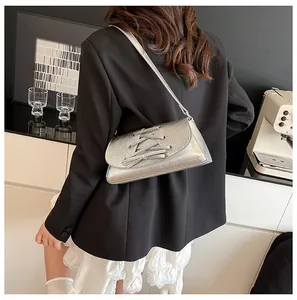 Silver metallic crossbody bag with lace-up detail and wrinkled texture on shoulder strap