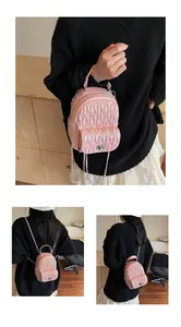 Detail view of mini pink quilted backpack with crystal studs and silver chain straps