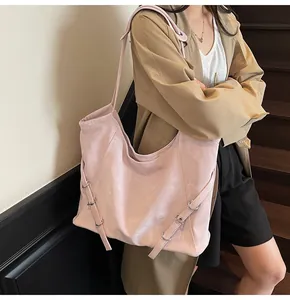 Detailed view of pink leather tote bag with side buckle straps and long shoulder handles
