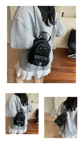 Close-up of black pleated texture and silver stud details on a fashion backpack