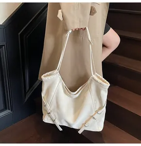Close-up of creamy white oversized tote bag on shoulder with decorative drawstring details