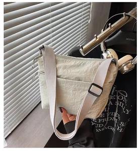 Dettaglio della tracolla regolabile e del tessuto in nylon stropicciato della borsa casual