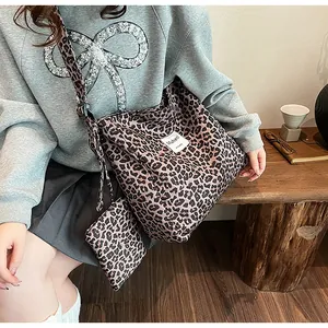 Detail of leopard print tote bag with adjustable shoulder strap and matching pouch