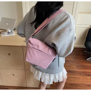 Dettaglio della borsa a tracolla in nylon rosa con cinturino largo e tessuto testurizzato