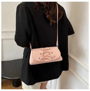 Pale pink bow crossbody bag shown on a model with a black blazer for a stylish look