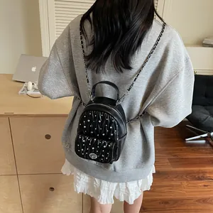 Chic black matelassé mini backpack with silver studs and chain straps for women