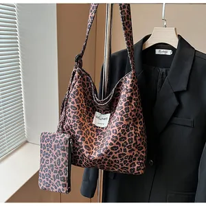 Close-up of leopard print tote bag with matching pouch on a fashion display rack