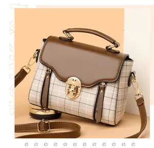 Detail of vintage plaid handbag featuring gold twist lock and PU leather texture