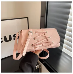 Detail of pink faux leather bag featuring silver metal eyelets and cross lace decoration