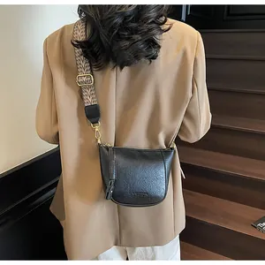 Detail eines verstellbaren breiten Schultergurts mit Vintage-Jacquard-Muster auf Tasche