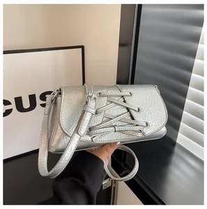 Silver metallic crossbody bag featuring pleated texture and lace-up ribbon detail