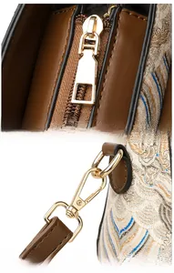 Détail de la fermeture éclair dorée et de la boucle sur un sac vintage en jacquard
