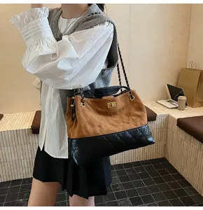 Detail of quilted leather tote bag with chain strap and gold buckle on a model