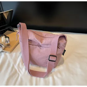 Dettaglio borsa a tracolla in nylon rosa con tracolla regolabile ed etichetta nera