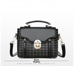 Detail of vintage plaid crossbody bag with gold lock and detachable black strap