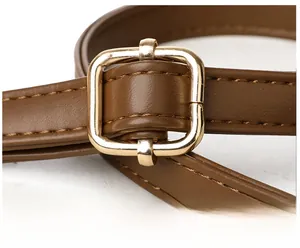 Détail de la bandoulière en cuir marron avec boucle dorée pour ajuster la longueur du sac