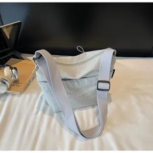 Dettaglio borsa a tracolla in nylon grigio chiaro con tessuto testurizzato e cinghia