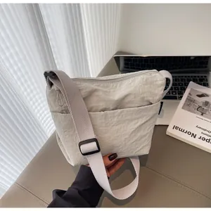 Dettaglio della borsa a tracolla in nylon grigio chiaro con tracolla regolabile e tasca