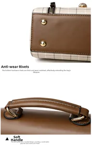 Detail of metal anti-wear rivets and soft leather handle on plaid crossbody bag