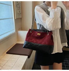Close-up of quilted tote bag with gold twist lock and burgundy black contrast leather