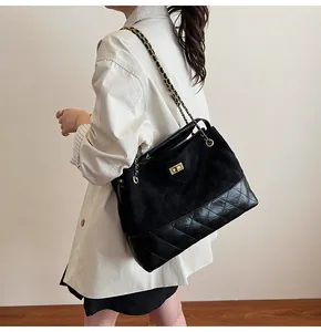 Close-up of quilted tote bag featuring chain strap and textured patchwork design