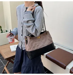 Close-up of dual-tone tote bag with diamond quilting and elegant gold chain strap