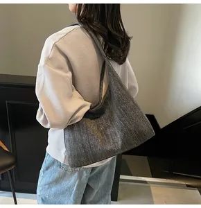 Detail der grauen Denim-Tasche mit strukturierter Oberfläche und minimalistischem Design