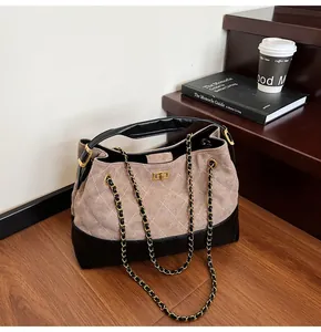Detail of diamond quilted tote bag with chain strap and metallic twist lock closure