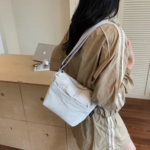 Borsa a tracolla minimalista in nylon grigio chiaro con tasche a zip e tracolla a nastro