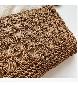 Close-up of brown straw woven tote showing detailed hexagonal star pattern and inner lining
