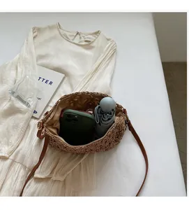 Spacious interior of woven straw tote bag holding a smartphone and folding umbrella