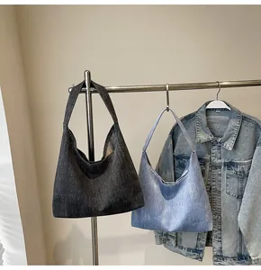 Detailansicht großer Jeans-Einkaufstaschen in Dunkelgrau und Hellblau mit breiten Trägern