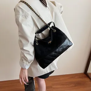 Quilted black tote bag with gold chain strap shown in a lifestyle fashion setting