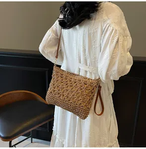 Detailed view of hollow flower woven texture and brown leather strap on summer tote bag