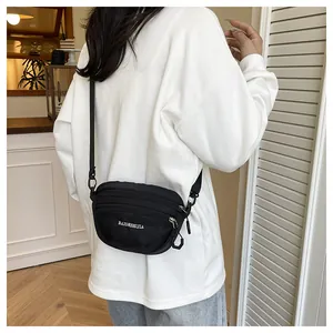 Rear view of a model wearing a black waterproof nylon crossbody bag with adjustable strap
