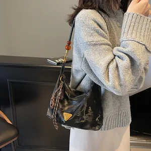 Borsa hobo retrò in pelle nera con logo dorato e tracolla con perline ambrate