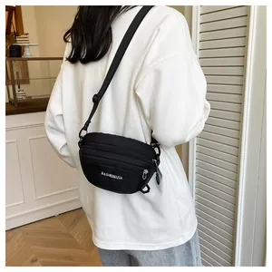 Back view of black waterproof nylon chest bag on a model showing practical fit and size