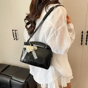 Schicke schwarze Lackleder-Beuteltasche mit Spitzenschleife und Perlenanhänger